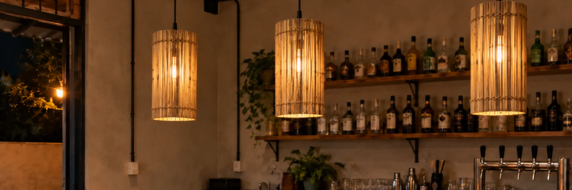 Balcão de bar com pendentes cilindro de bambu acesos